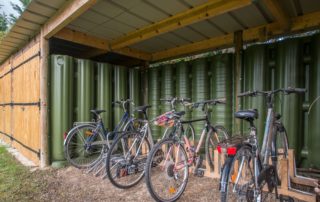 abri de vélo qui récupère et stocke l'eau de pluie